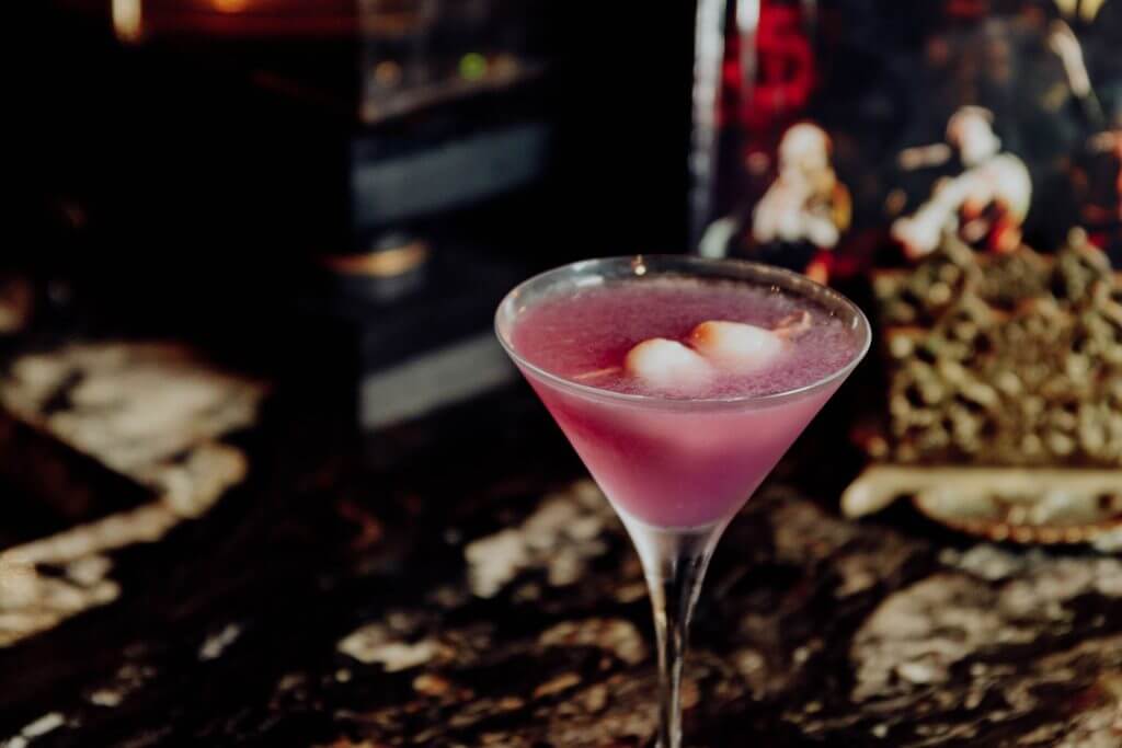 Pink drink in a martini glass atop a marble bar