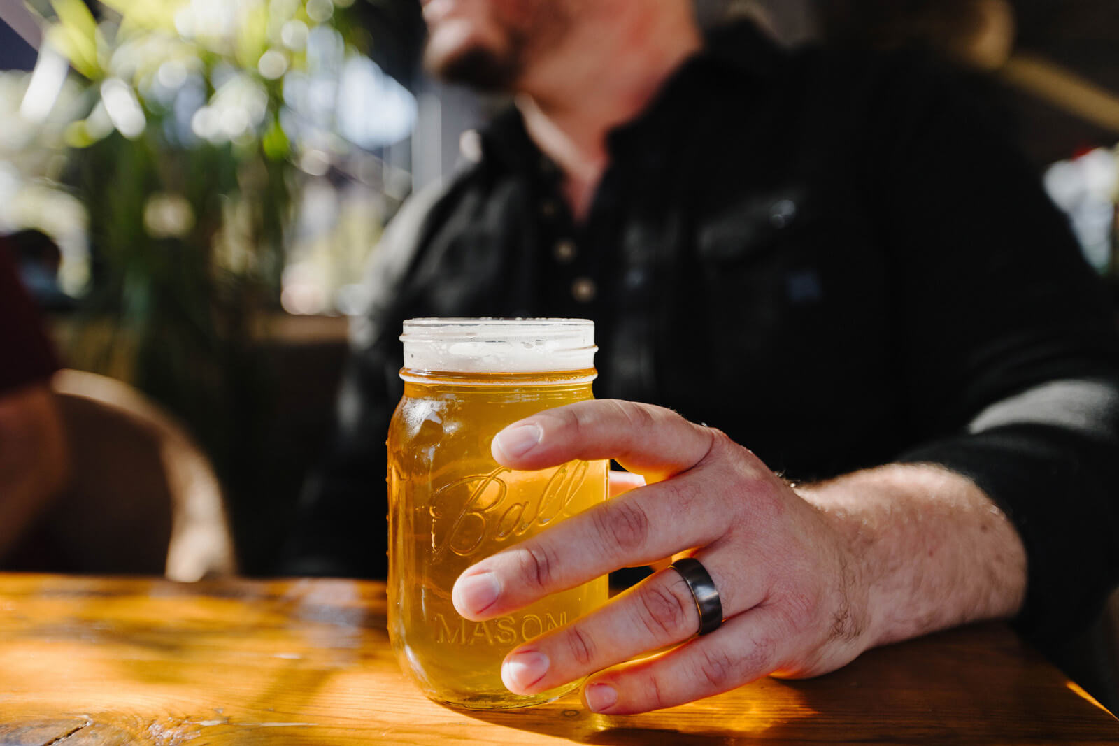 Meetings Close up of hand holding mason jar full of beer