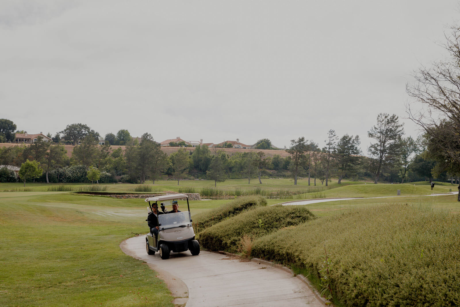 Taste of the Santa Ynez Valley Hotel Offers Two men in a golf cart driving on cart path on a golf course in the Santa Ynez Valley