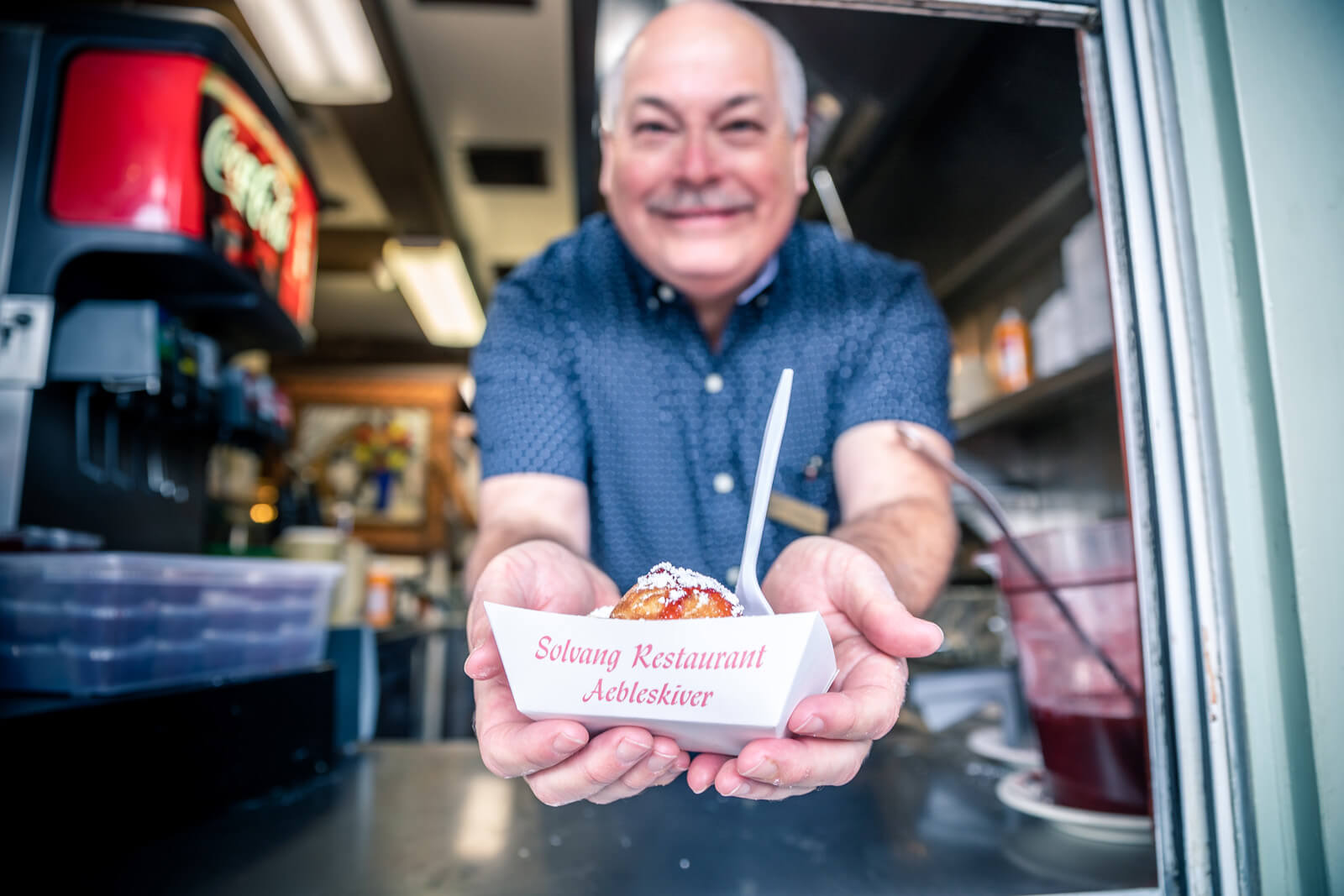 Solvang Man serving food at a restaurant window in Solvang, CA
